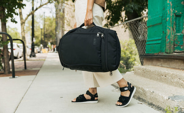 A person carrying the Techonaut 30 like a duffel with the grab handle.